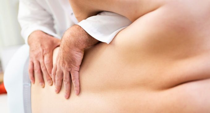 Arzt prüft Rücken eines Patienten