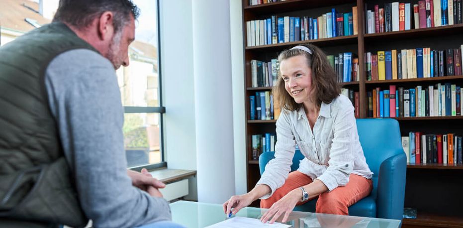 Eine Sozialarbeiterin berät einen Patienten