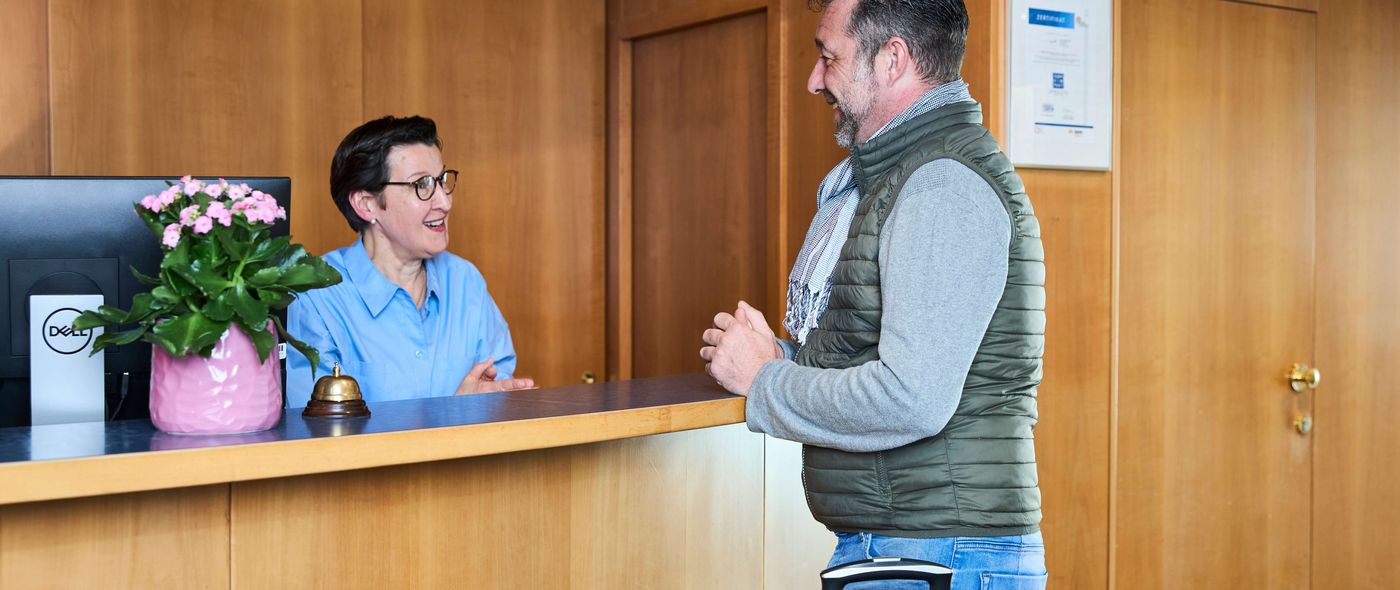 Patient checkt am Klinik-Empfang ein