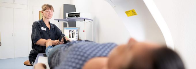 Pflegekraft bereitet Patient auf Knochendichtemessung vor