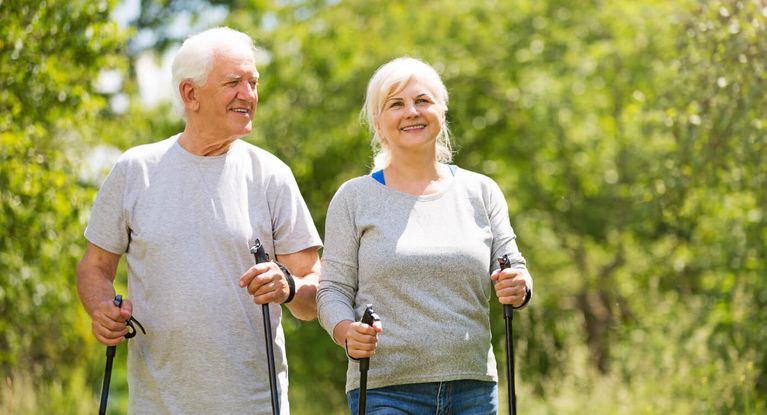 Älteres Paar wandert mit Nordic Walking Stöcken